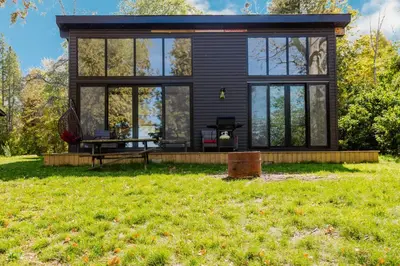 a black tiny house with a large window at Lakefront Englewood Villas Private BBQ and Lakeview in Lakefield