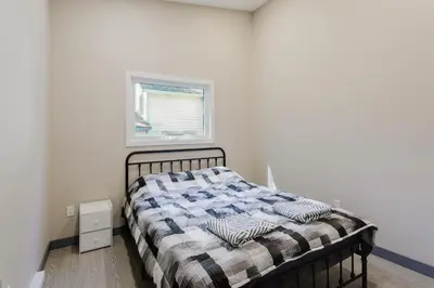 a bedroom with a bed with a blanket on it at Lakefront Englewood Villas Private BBQ and Lakeview in Lakefield