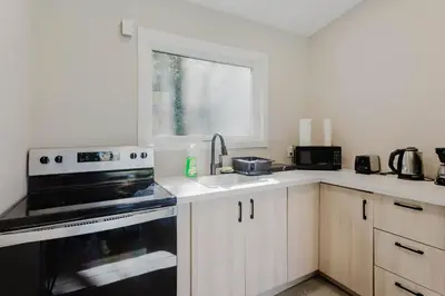 a kitchen with a stove and a sink and a window at Lakefront Englewood Villas Private BBQ and Lakeview in Lakefield
