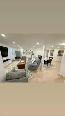 a large living room with couches and a table at Studio 8848 - Sleeps 8 in Brampton