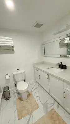 a bathroom with a toilet and a sink and a mirror at Studio 8848 - Sleeps 8 in Brampton