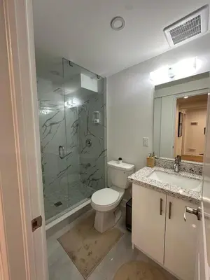a bathroom with a toilet and a glass shower at Studio 8848 - Sleeps 8 in Brampton