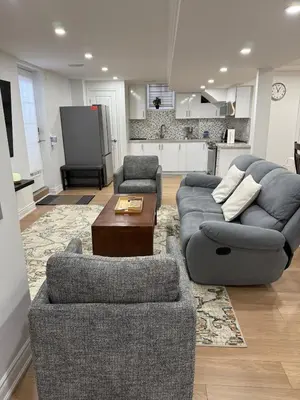 a living room with two couches and a table at Studio 8848 - Sleeps 8 in Brampton