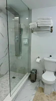 a bathroom with a toilet and a glass shower at Studio 8848 - Sleeps 8 in Brampton