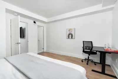 a bedroom with a bed and a desk and a computer at Chic 3BR Ossington Hub Near Subway & Shops in Toronto