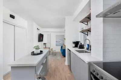 a white kitchen with white counters and white appliances at Chic 3BR Ossington Hub Near Subway & Shops in Toronto