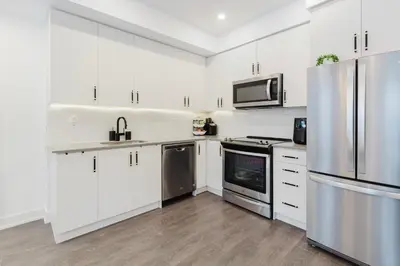 a kitchen with white cabinets and stainless steel appliances at Luxury Elegant Full house Escape Premium Comfort in Mississauga