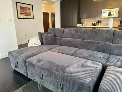 a gray couch in a living room with a kitchen at Dreamspace 3 Bdrms with 1 Parking in Toronto