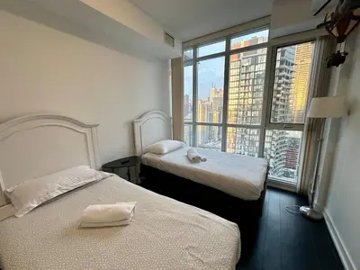 a hotel room with two beds and a large window at Dreamspace 3 Bdrms with 1 Parking in Toronto