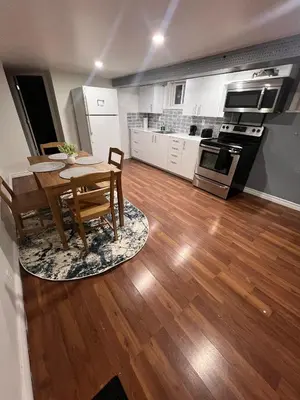 a kitchen and dining room with a table and chairs at Charming 2 Bedroom Basement Apartment in Toronto