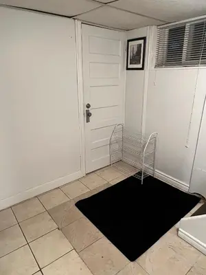 a room with a door and a black rug at Charming 2 Bedroom Basement Apartment in Toronto