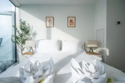 a white bed with two white flowers on it at Stunning Lake and CN Tower View with 2BR 2BA Free Parking in Toronto