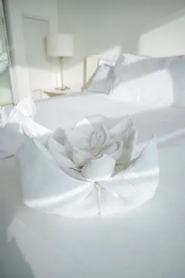a white flower sitting on a white bed at Stunning Lake and CN Tower View with 2BR 2BA Free Parking in Toronto