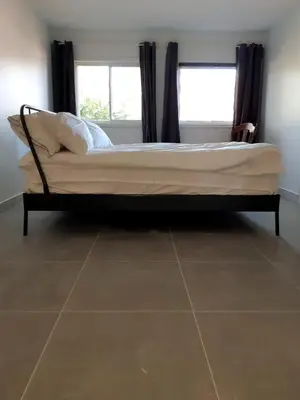 a bed in a bedroom with a tile floor at Zen-out Home in Mississauga