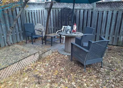 a patio with chairs and a table with an umbrella at Zen-out Home in Mississauga