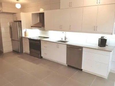 a kitchen with white cabinets and a refrigerator at Zen-out Home in Mississauga