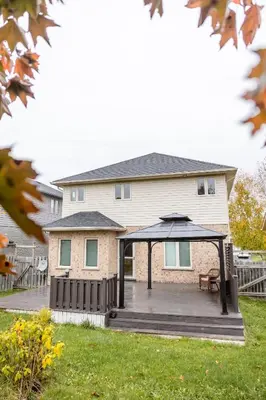 a house with a deck with an umbrella at The Bards Roost - 3BR King Ensuite Family Friendly in Stratford