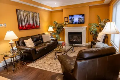 a living room with leather couches and a fireplace at The Bards Roost - 3BR King Ensuite Family Friendly in Stratford