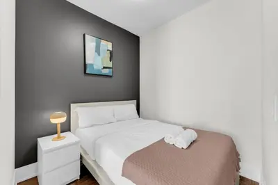 a small bedroom with a bed and a night stand at Eleve Toronto Residences in Toronto