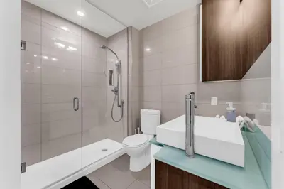 a bathroom with a sink and a toilet and a shower at Eleve Toronto Residences in Toronto