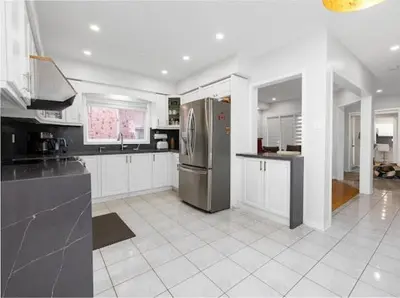 a kitchen with a stainless steel refrigerator and white cabinets at Bright 3BR Home in Richmond Hill free parking in Richmond Hill