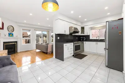 a kitchen with a stainless steel refrigerator and a living room at Bright 3BR Home in Richmond Hill free parking in Richmond Hill