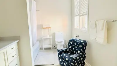 a bathroom with a chair and a toilet at Bright 3BR Home in Richmond Hill free parking in Richmond Hill
