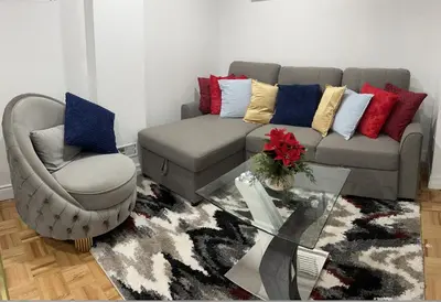 a living room with a couch and a chair at Brand New Comfortable and Cozy Apartment near the Airport in Toronto