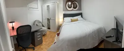 a bedroom with a bed and a desk and a computer at Brand New Comfortable and Cozy Apartment near the Airport in Toronto