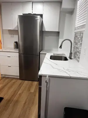 a kitchen with a stainless steel refrigerator and a sink at Brand New Comfortable and Cozy Apartment near the Airport in Toronto