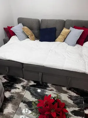 a couch with pillows on it in a room at Brand New Comfortable and Cozy Apartment near the Airport in Toronto