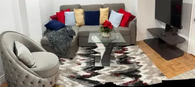 a living room with a couch and a table at Brand New Comfortable and Cozy Apartment near the Airport in Toronto