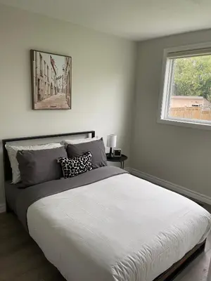 a bedroom with a large bed and a window at Hamilton Haven Private Rooms in Hamilton