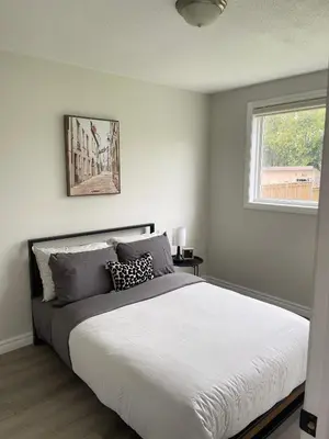 a bedroom with a large white bed with a window at Hamilton Haven Private Rooms in Hamilton