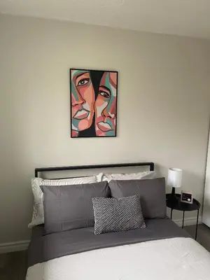 a bedroom with a bed with two pictures on the wall at Hamilton Haven Private Rooms in Hamilton