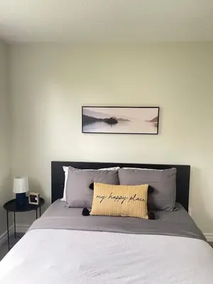 a bedroom with a bed with a picture on the wall at Hamilton Haven Private Rooms in Hamilton