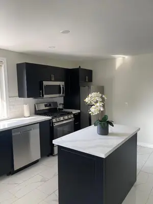 a kitchen with black cabinets and a white counter top at Hamilton Haven Private Rooms in Hamilton