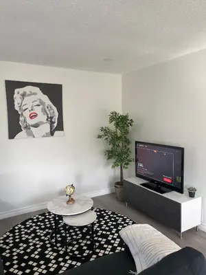 a living room with a tv and a table at Hamilton Haven Private Rooms in Hamilton