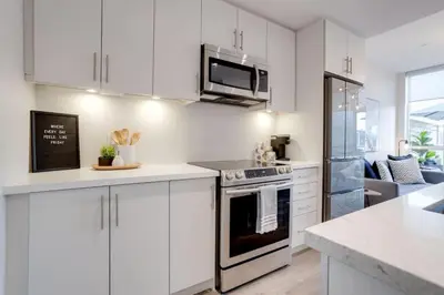a kitchen with white cabinets and a stove top oven at Lovely Open Concept Friday Harbor Resort Condo in Innisfil