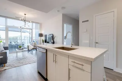 a kitchen with a sink and a living room at Lovely Open Concept Friday Harbor Resort Condo in Innisfil