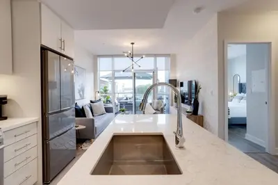 a kitchen with a sink and a living room at Lovely Open Concept Friday Harbor Resort Condo in Innisfil