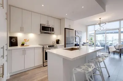 a kitchen with white cabinets and a counter top at Lovely Open Concept Friday Harbor Resort Condo in Innisfil