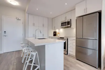a kitchen with white cabinets and stainless steel appliances at Lovely Open Concept Friday Harbor Resort Condo in Innisfil