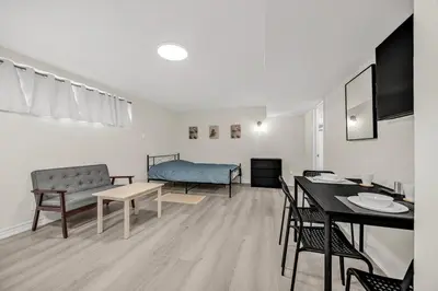 a living room with a dining table and a bed at Large Studio Room No 1 in North York in Toronto