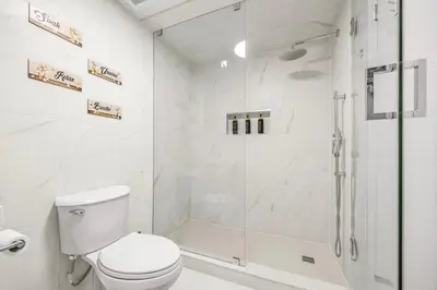 a white bathroom with a shower and a toilet at Large Studio Room No 1 in North York in Toronto