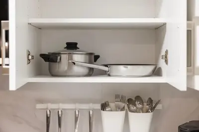 a kitchen shelf with utensils and a pot and pans at Large Studio Room No 1 in North York in Toronto