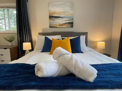 a bedroom with a bed with blue and yellow pillows at Academic Scholar Modern Apt Near Western U, Trails, Parking in London