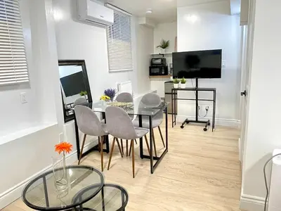 a dining room with a table and chairs and a television at Academic Scholar Modern Apt Near Western U, Trails, Parking in London
