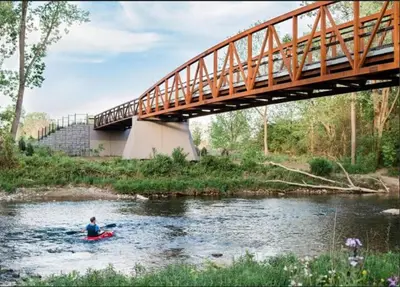 a person in a kayak in a river under a bridge at Academic Scholar Modern Apt Near Western U, Trails, Parking in London
