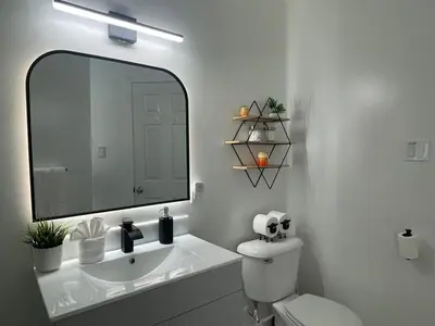 a white bathroom with a sink and a mirror at Academic Scholar Modern Apt Near Western U, Trails, Parking in London